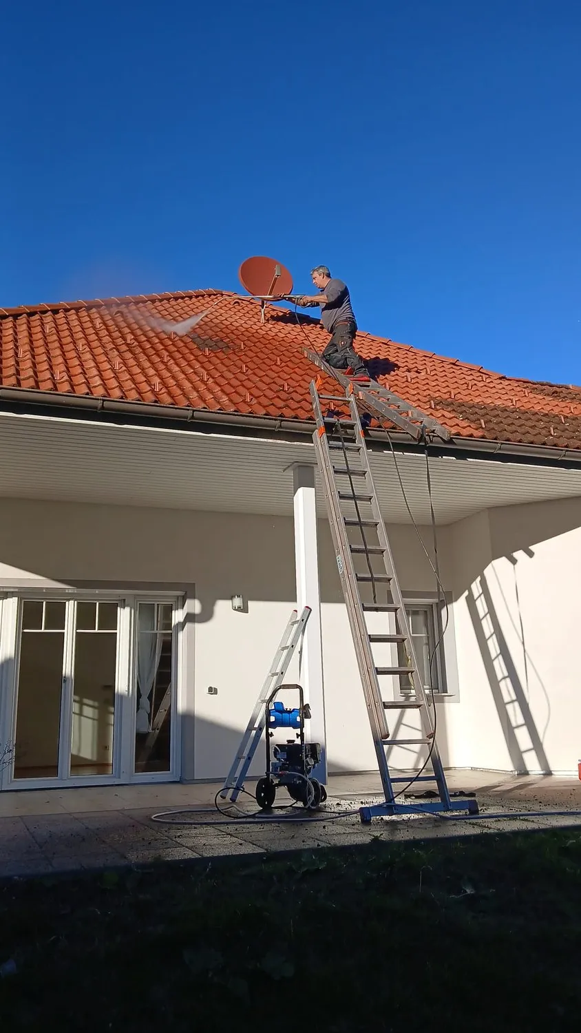 Bärenstark im Einsatz auf einem Ziegeldach, unten Leiter und Hochdruckgerät